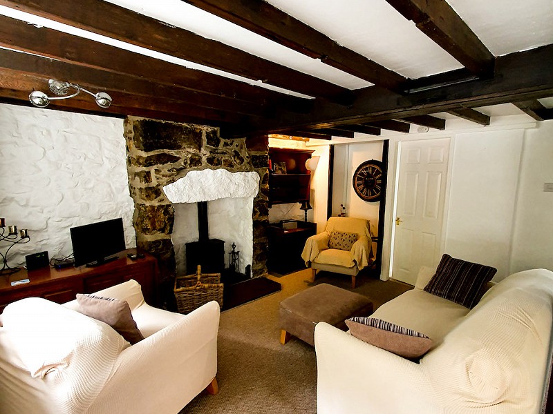 The lounge boasts a traditional beamed ceiling with stone walls and a welcoming wood burning stove.